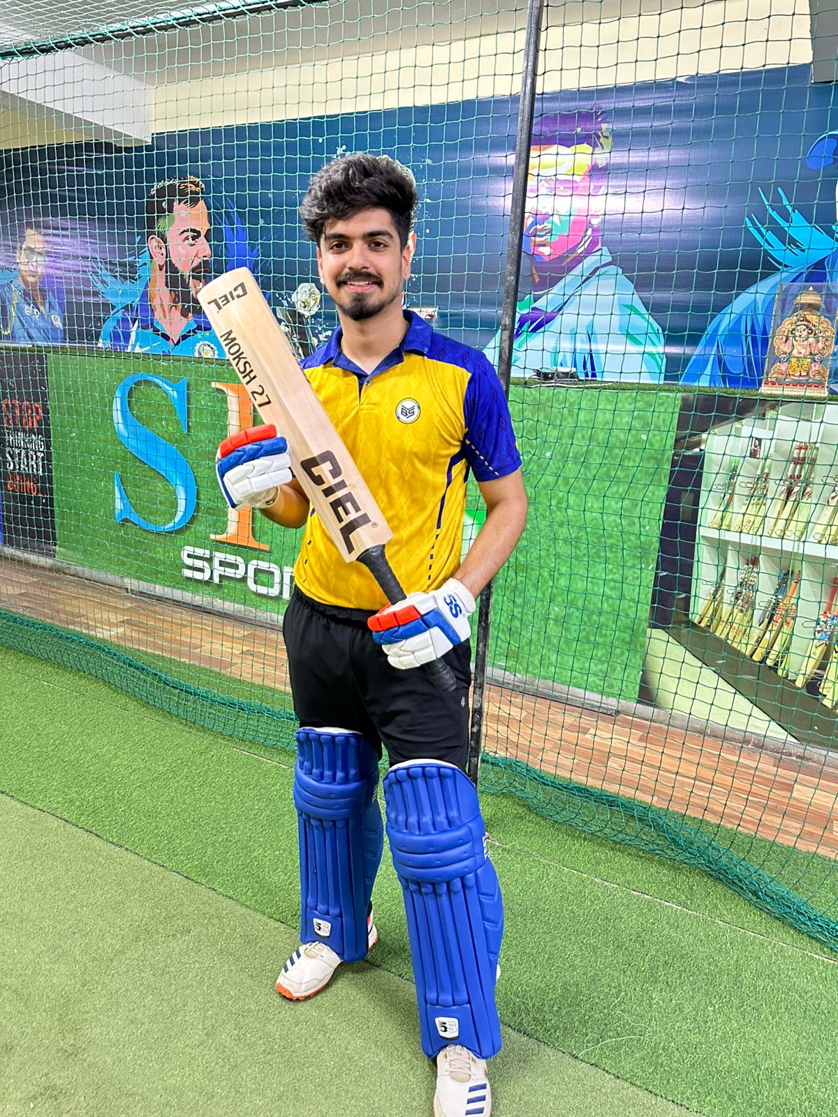 player is holding a player edition leather cricket bat